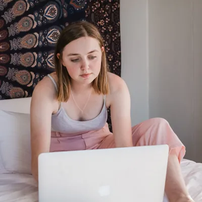 woman watching feminist porn on her laptop in bed