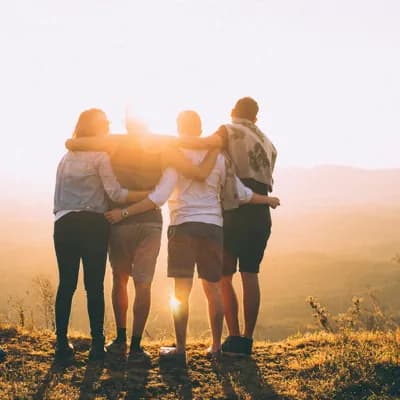 group of people outside embracing as they look at the landscape