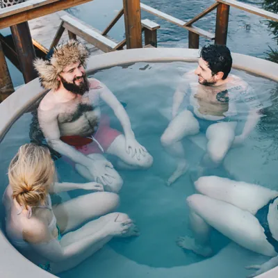 two couples talking in a hot tub together